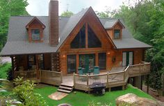 a log cabin with deck and patio in the woods