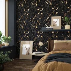 a bed room with a neatly made bed next to a window and plants on the wall