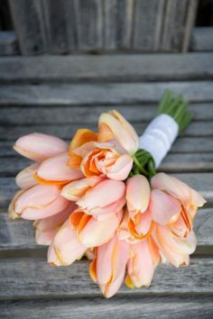 a bouquet of flowers sitting on top of a wooden bench