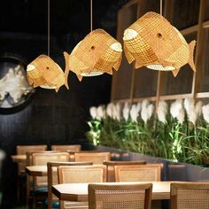 several fish lamps hanging from the ceiling in a restaurant