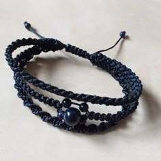 two black bracelets with beads on them