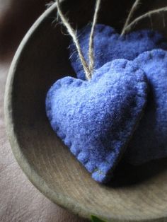 two blue heart shaped cushions in a wooden bowl