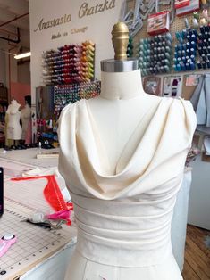 a mannequin is shown in front of a display of sewing tools and fabrics