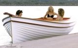 three women sitting in a boat on the water