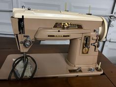 an old sewing machine sitting on top of a wooden table