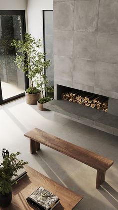 a living room with a fire place and two tables in front of the fireplace that has logs on it