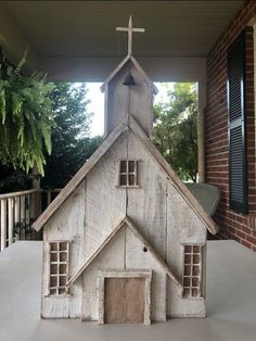 a small wooden church with a cross on top