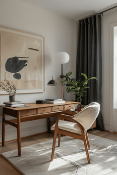 a wooden desk sitting in front of a window next to a chair and lamp on top of a rug