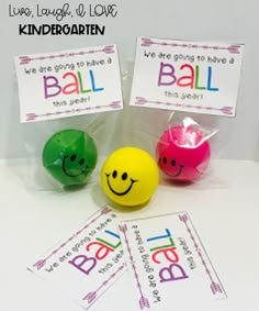 three plastic balls with words and smiley faces on them, sitting next to each other