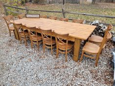 a large wooden table surrounded by chairs and firewood stacked on top of each other