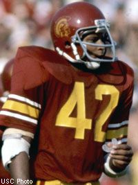 a football player holding a ball in his hand and wearing a uniform with the number 42 on it