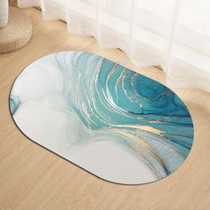 a round rug with blue and gold swirls on the floor next to a window