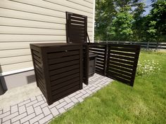 an outdoor area with two chairs and a trash can on the side of a house