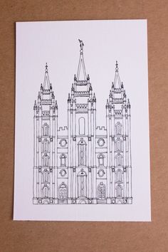 a black and white drawing of a building with spires on the top is sitting on a piece of paper