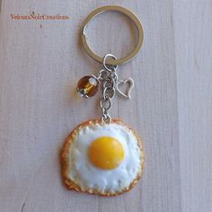 a fried egg on a piece of bread with a heart shaped key chain attached to it