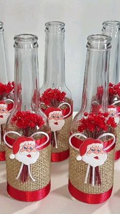 several vases with red flowers in them and santa clause on the top one is empty