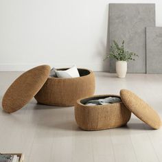 two round foot stools sitting on top of a wooden floor next to a potted plant