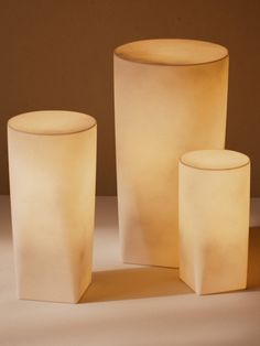 three white vases sitting next to each other on a table