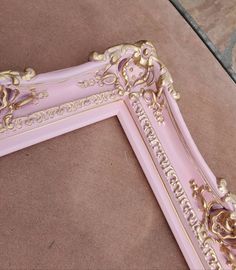 a pink and gold frame sitting on the ground