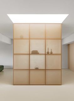 an empty room with several shelves on the wall and a green couch in front of it