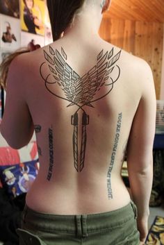 the back of a woman's body with tattoos on her upper and lower part