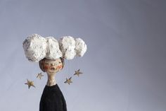 a doll with stars hanging from it's head and hair in the shape of clouds