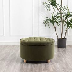 a green round ottoman next to a potted plant