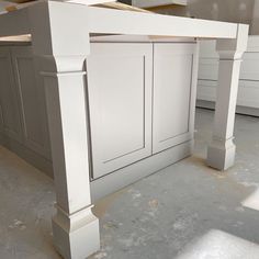 an unfinished kitchen island in the middle of being built with white cabinetry and drawers