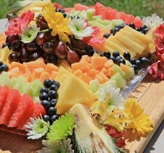 a platter filled with watermelon, grapes, melons and other fruits