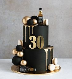 a black and gold 30th birthday cake with alcohol on top