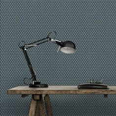 a desk lamp sitting on top of a wooden table in front of a blue wall