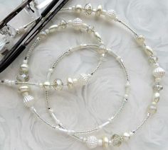 CJ's Inspirations: "Creamy Pearl" This beautiful lanyard was made with a collection of sparkling crystals, glass beads, and glass pearls. It makes a wonderful addition to your lanyard collection or a great gift for others. Options: To ensure durability and long-lasting wear, this lanyard has very strong wiring, triple crimping beads, and split jump rings.  Measurement: in inches end to end with the eyeglass loops ------------ This eyeglass chain has already been created and is ready to ship. The White Glasses Chains With Lobster Clasp And Round Beads, Lanyard Crystals, Pearl Mask, Beaded Eyeglass Chain, Glasses Lanyard, Glasses Chains, Mask Lanyard, Need A Break, Eyeglass Holder