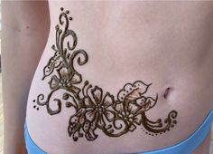 a woman's stomach with henna tattoos on it