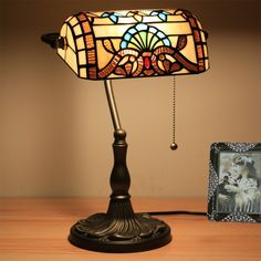 a lamp that is sitting on top of a table next to a picture and a frame