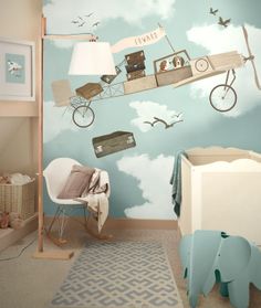 a baby's room with an elephant and airplane mural on the wall next to a crib