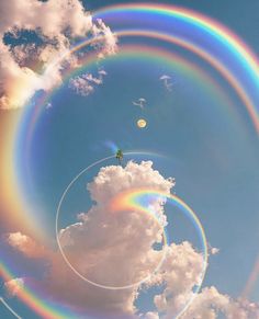 two rainbow rings are in the sky above clouds