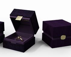 an open box with a ring in it and two other boxes next to it that have rings inside