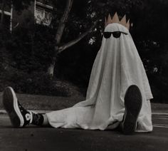 a black and white photo of a person laying on the ground with a blanket covering them