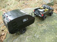 a toy truck pulling a trailer on top of a rock