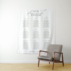 a chair sitting in front of a white wall with a seating chart hanging on it