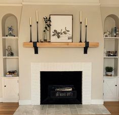 a living room with a fireplace and some candles on the mantels above it