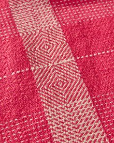 a close up view of a red and white checkered fabric with an interesting design