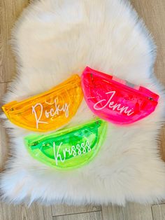 three personalized fanny bags sitting on top of a white fur rug