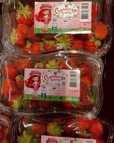 three plastic containers filled with strawberries on display