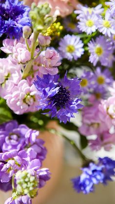 a bunch of purple and white flowers in a vase