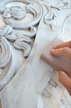 a person using a sponge to paint an ornate design