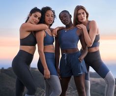 three women in sports wear posing for the camera