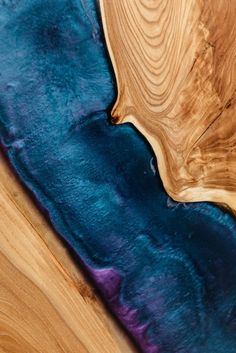 a wooden table with blue and purple designs on it's surface is shown in close up