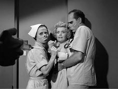 three people in scrubs and masks are taking a selfie with one person's hand