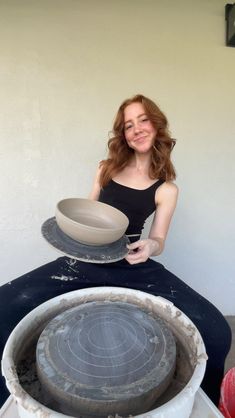 a woman sitting on the ground holding a bowl